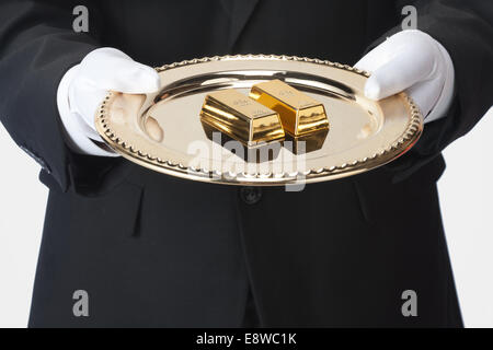 Waiter holding un bac de barres d'or Banque D'Images