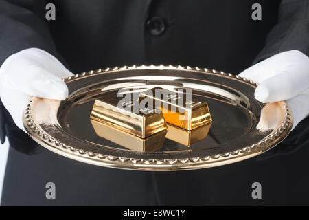 Waiter holding un bac de barres d'or Banque D'Images