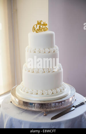 Un simple glaçage blanc traditionnel gâteau à trois niveaux couverts sur jour de mariage UK Banque D'Images