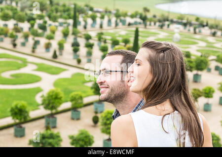 Profil d'un jeune couple heureux bénéficiant d'un beau jardin à la française au cours d'une belle journée. L'accent est sélective sur la femme. Banque D'Images