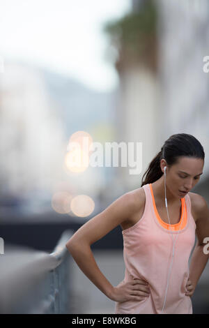 Femme se reposant après running on city street Banque D'Images