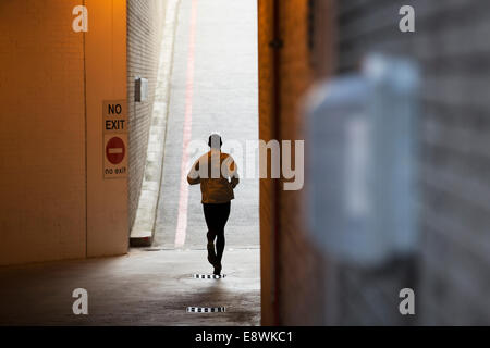 Homme qui court à travers les rues de la ville Banque D'Images