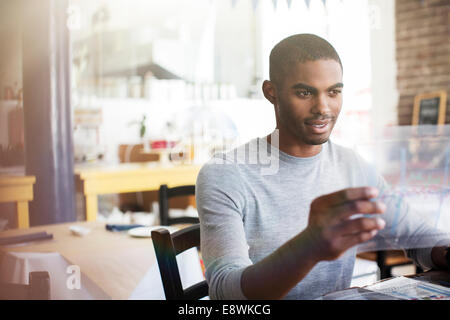 Businessman examining documents à in cafe Banque D'Images