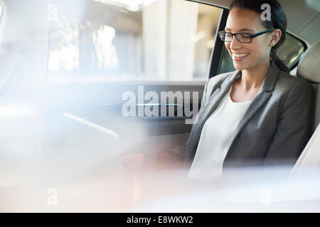 Businesswoman using laptop in location de siège arrière Banque D'Images