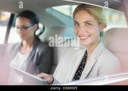 Businesswoman using digital tablet in location de siège arrière Banque D'Images