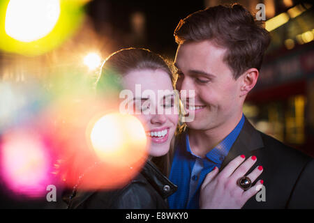 Couple hugging on city street Banque D'Images