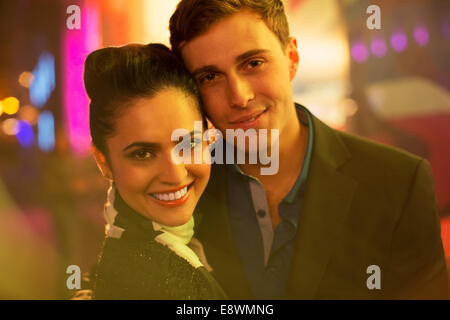 Couple hugging on city street at night Banque D'Images