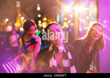 Amis jouant sur city street at night Banque D'Images