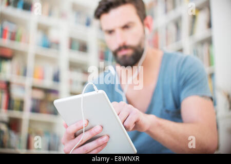 Close up of man listening to music on digital tablet Banque D'Images