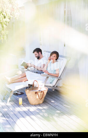 Couple sur des chaises de terrasse en bois Banque D'Images