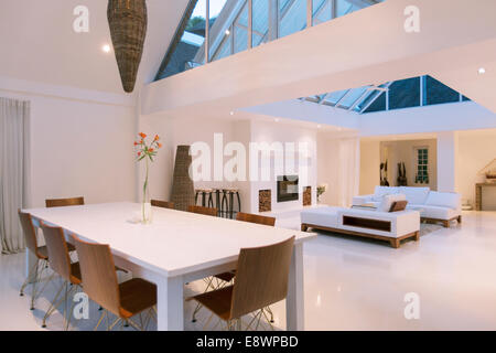 Table à manger, des canapés et des lucarnes en salle à manger et un salon à aire ouverte de maison moderne Banque D'Images