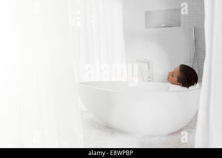 Woman relaxing in baignoire dans salle de bains moderne Banque D'Images