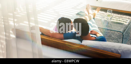 Couple relaxing together on sofa in modern living room Banque D'Images