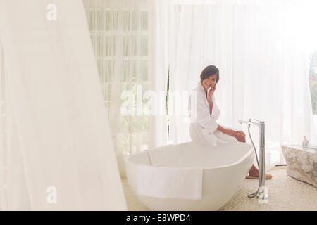 Woman running baignoire dans salle de bains moderne Banque D'Images