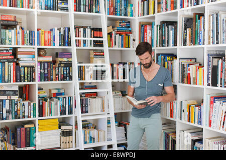 L'homme écoute de la musique dans la bibliothèque Banque D'Images