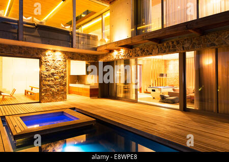 Maison moderne avec vue sur la piscine éclairée la nuit Banque D'Images