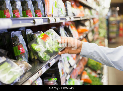 Close up of man holding produire in grocery store Banque D'Images