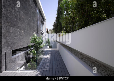 Passerelle en bois avec mur blanc en retrait et l'extérieur de maison H, Israël, Moyen Orient. Banque D'Images