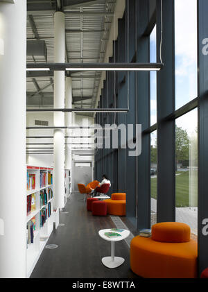 Femme assise lisant près de bibliothèques dans le Kent et l'histoire de la bibliothèque, du centre de Maidstone, Angleterre, Royaume-Uni. Banque D'Images