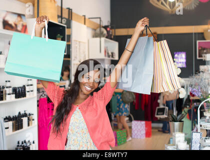 Woman carrying shopping bags in store Banque D'Images