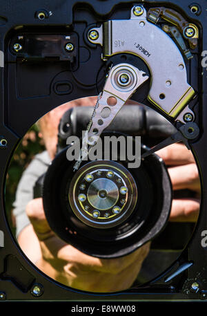 Une réflexion d'un photographe à l'aide d'une caméra dans un plateau de disque dur Banque D'Images