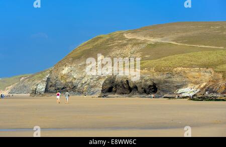 Un couple en train de marcher le long de la plage de sables Penhale Rolvenden Cornwall England uk Banque D'Images