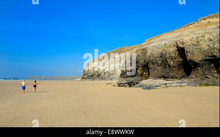 Un couple en train de marcher le long de la plage de sables Penhale Rolvenden Cornwall England uk Banque D'Images