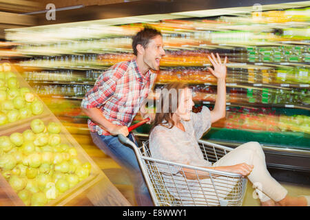 Blurred view of couple playing in grocery store Banque D'Images