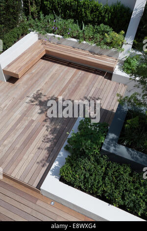 Une série de rendus et de murs peints et des lits surélevés. Terrasse en bois avec banc flottant. Coin salon. . Jardin de la Cour à Hampstead, au nord de Londres, conçu par Modular Banque D'Images