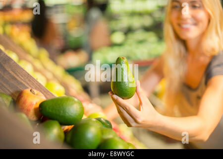 Close up of woman holding produire in grocery store Banque D'Images