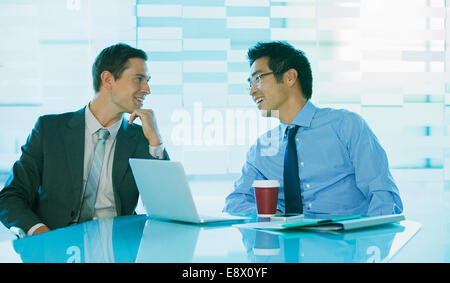 Businessmen talking at table in office building Banque D'Images