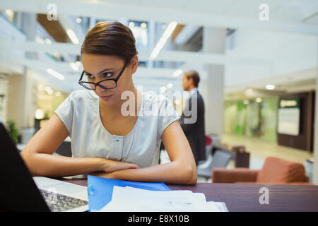 Businesswoman working on laptop in office building Banque D'Images