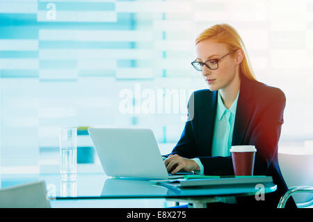 Businesswoman working on laptop in office building cafe Banque D'Images