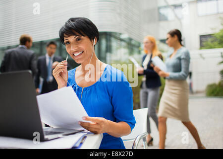 Businesswoman talking on headset at table in office building Banque D'Images
