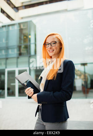 Businesswoman walking à l'extérieur du bâtiment de bureaux Banque D'Images
