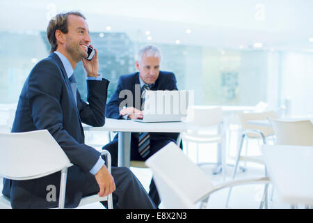 Businessman talking on call phone in office building cafe Banque D'Images