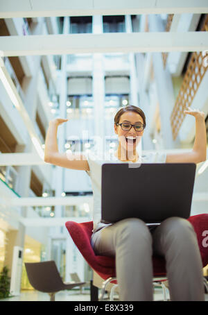 Businesswoman getting excité dans office building Banque D'Images