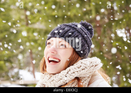 Woman admiring la neige qui tombe à l'extérieur Banque D'Images