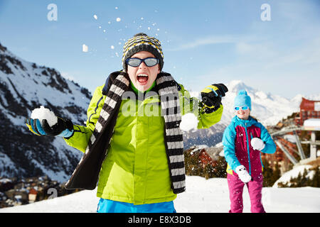 Frères et sœurs having snowball fight Banque D'Images