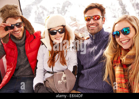 Friends smiling together on ski lift Banque D'Images