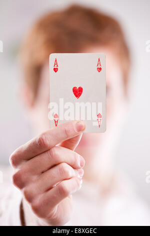 Une tête rouge guy montrant une carte Ace of Hearts Banque D'Images