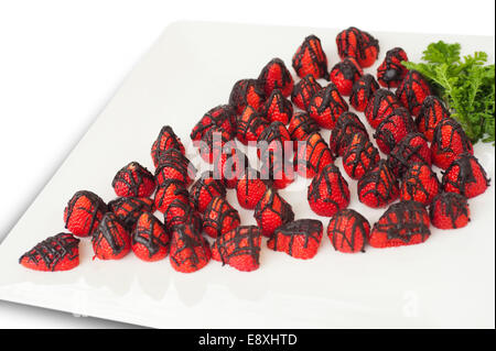De fraises enrobées de chocolat sur le bac, sur fond blanc Banque D'Images