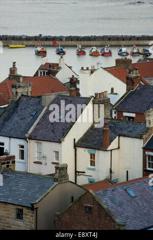 Vue de haut sur les toits de petite et pittoresque des chalets, de bateaux dans le port et la mer au-delà - village balnéaire de Staithes, North Yorkshire, Angleterre, Royaume-Uni. Banque D'Images