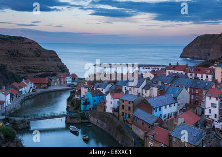 Compte tenu de soirée sunset sky, seaside cottages pittoresques, de hautes falaises et port de vieux village de pêcheurs - Staithes, North Yorkshire Coast, England, UK. Banque D'Images