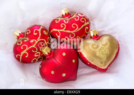 Décorations de Noël en forme de coeur repos doucement sur le tissu blanc. Banque D'Images