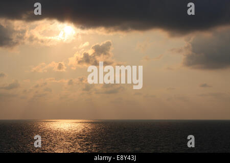 Soleil brille à travers les nuages au-dessus de la mer Banque D'Images