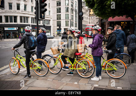 Groupe de cyclistes en attendant le feu de circulation pour changer à un Pelican Crossing dans la rue de Londres, Royaume-Uni Banque D'Images