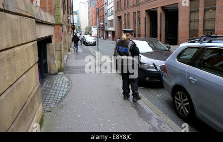 Manchester, UK. 16 octobre, 2014. Un gardien de parking voitures chèques sur Lloyd Street, où plus de 1700 billets ont été délivrés pour stationnement illégal de 2008 à 2013, le quatrième plus haut pour n'importe quelle rue dans le Grand Manchester. Crédit : John Fryer/Alamy Live News Banque D'Images