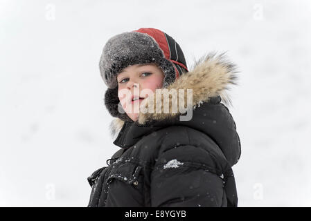 Teenage boy jouer dans la neige en hiver Banque D'Images