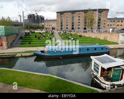 Par une chaude après-midi d'automne les élèves manger le déjeuner de freiner les cars sur l'astroturf mesures en dehors de l'Université des Arts de UAL dans Kings Cross par Regents Canal à Londres Angleterre Royaume-uni KATHY DEWITT Banque D'Images